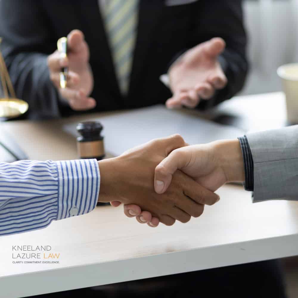 People shaking hands after a successful mediation done by the attorneys at Kneeland & Lazure Law.